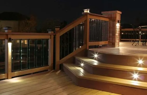 Warm amber recessed deck step lights illuminating multi-level composite deck at night