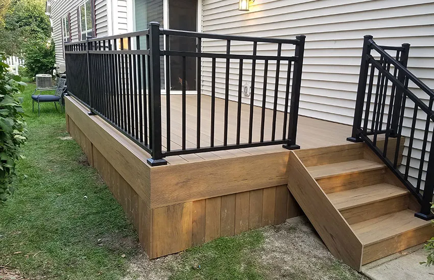 All-black aluminum deck railing with square balusters on composite deck with matching skirting