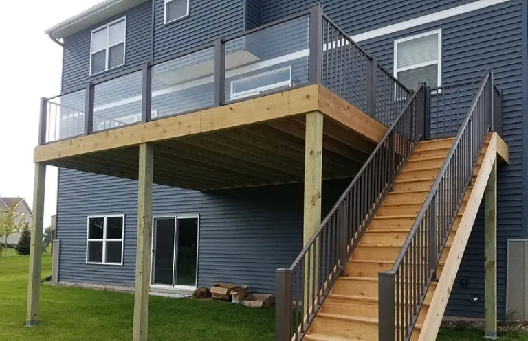 Second-story elevated deck with glass panel railings and aluminum posts on pressure-treated frame